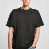 Model trägt ein schwarzes Build Your Brand BY102 Heavy Oversize T-Shirt mit überschnittenen Schultern und Jeans.