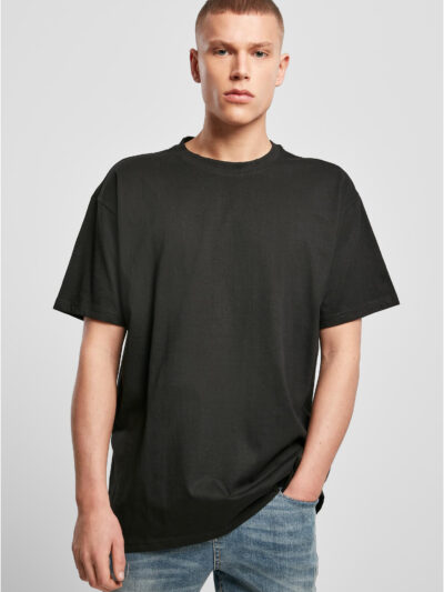 Model trägt ein schwarzes Build Your Brand BY102 Heavy Oversize T-Shirt mit überschnittenen Schultern und Jeans.